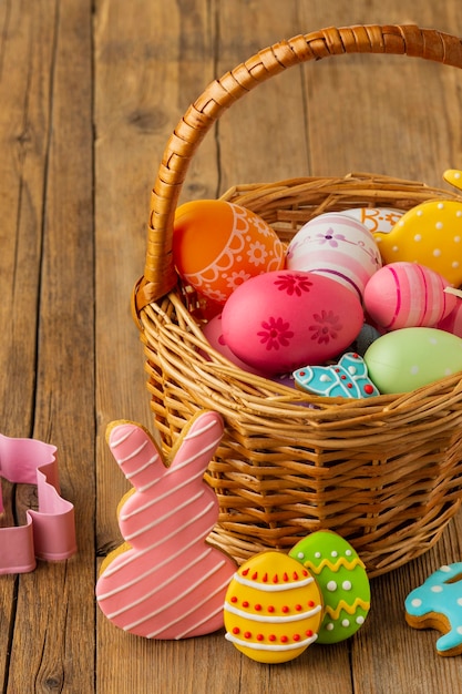 Alto ángulo de coloridos huevos de pascua en canasta con conejito