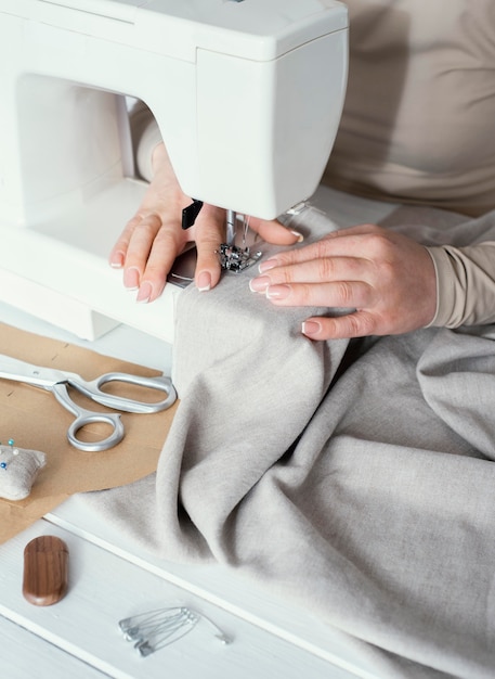 Alto ángulo de costurera con máquina de coser
