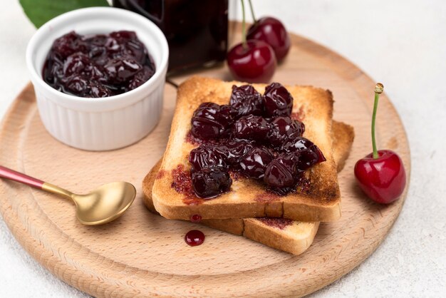 Alto ángulo deliciosa mermelada de cerezas en pan