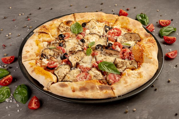 Alto ángulo de deliciosa pizza con tomate y albahaca