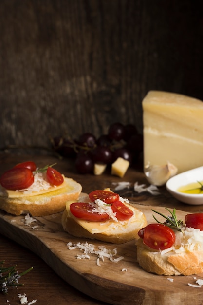 Alto ángulo delicioso queso con composición de tomates en la mesa