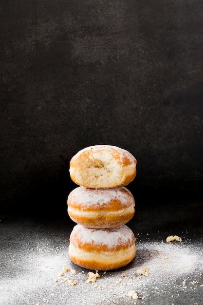 Alto ángulo de donas apiladas con azúcar en polvo