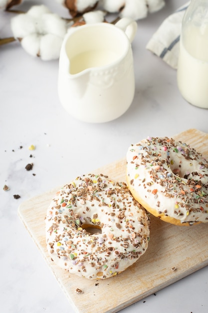 Foto gratuita alto ángulo de donas glaseadas con chispas y flor de algodón