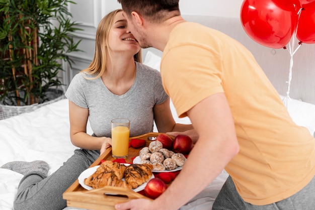 Alto ángulo feliz pareja besándose en el interior