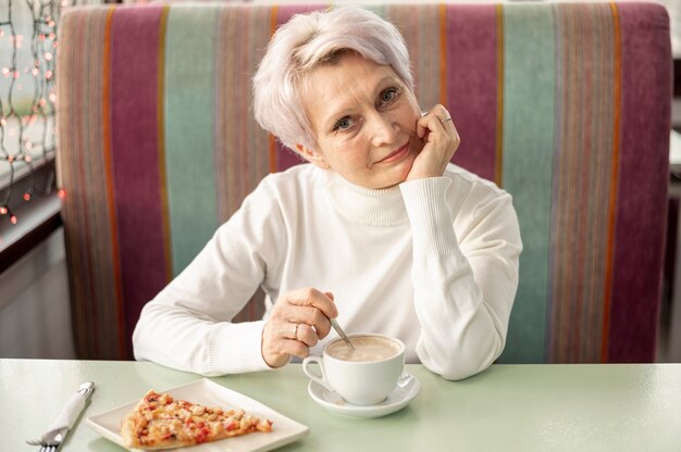 Alto ángulo femenino senior en el restaurante disfrutando de luch