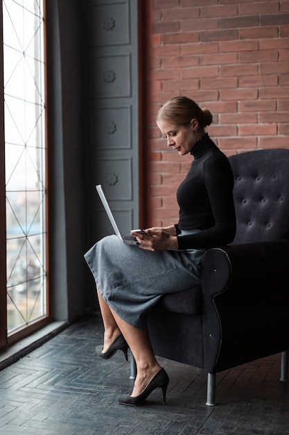 Alto ángulo femenino trabajando en la computadora portátil