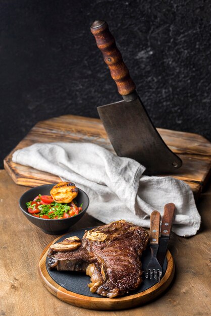 Alto ángulo de filete con ensalada y cuchilla