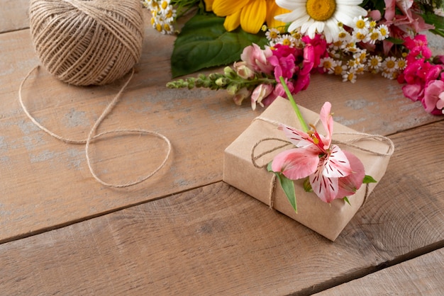 Foto gratuita alto ángulo de flores con regalo y etiqueta.