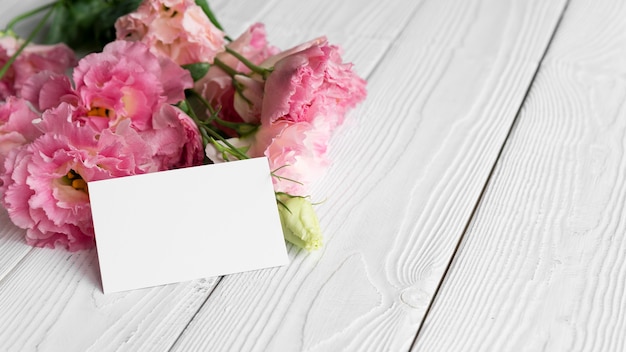 Alto ángulo de flores con tarjeta en blanco