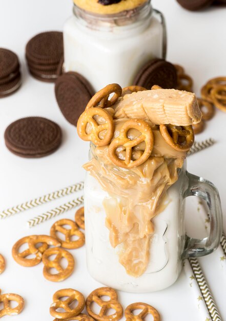 Alto ángulo de frascos de postre con galletas y pretzels.
