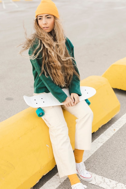 Foto gratuita alto ángulo hembra joven con patineta