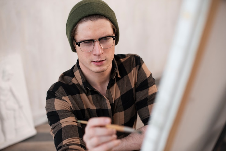 Foto gratuito alto ángulo hombre artista pintura sobre lienzo