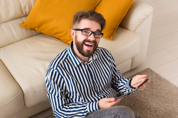 Alto ángulo de hombre feliz en casa con tableta