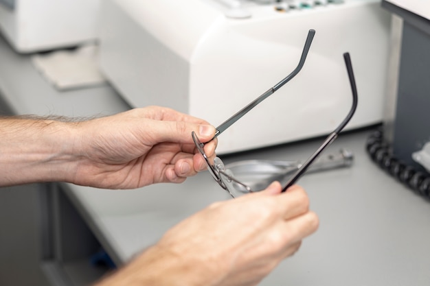 Alto ángulo del hombre recogiendo sus gafas del escritorio