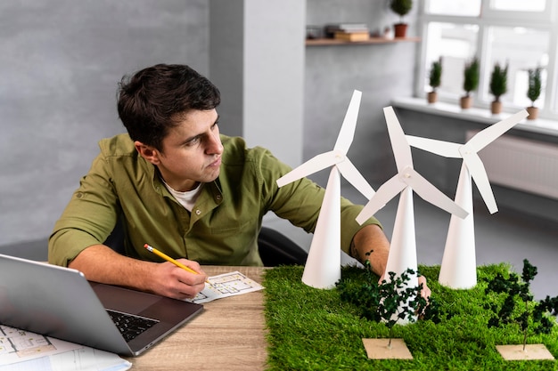 Alto ángulo de hombre trabajando en un proyecto de energía eólica ecológica