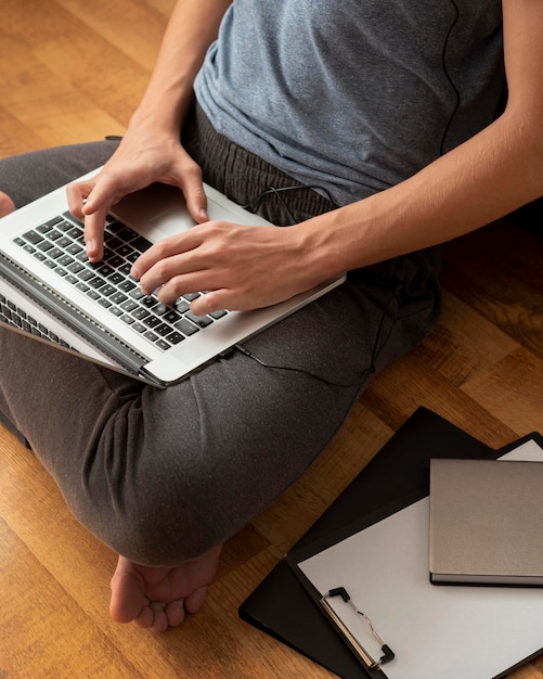 Alto ángulo de hombre usando laptop en casa en cuarentena para trabajar