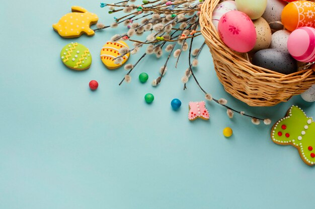 Alto ángulo de huevos de pascua en canasta con formas de conejito y mariposa