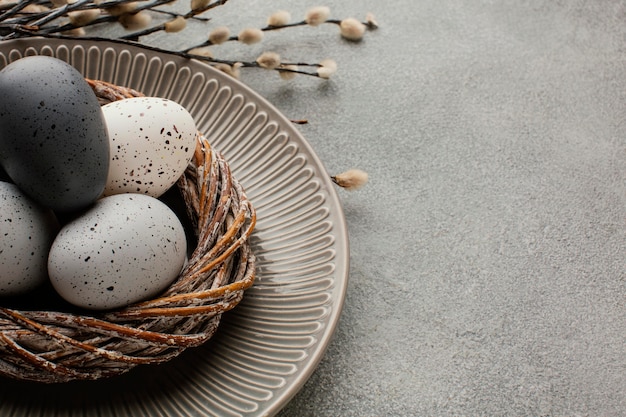 Alto ángulo de huevos de pascua de colores en la canasta con espacio de copia