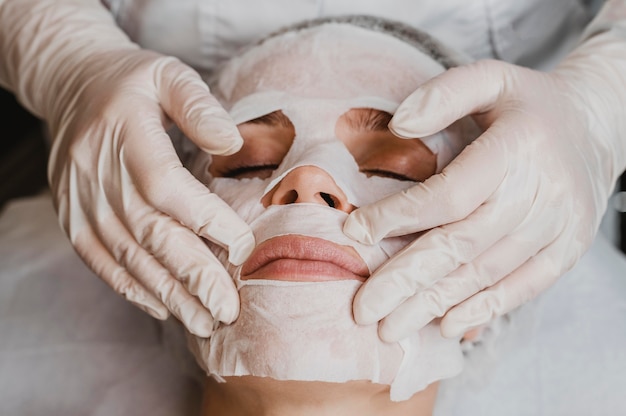 Foto gratuita alto ángulo de joven bella mujer recibiendo un tratamiento de mascarilla para la piel