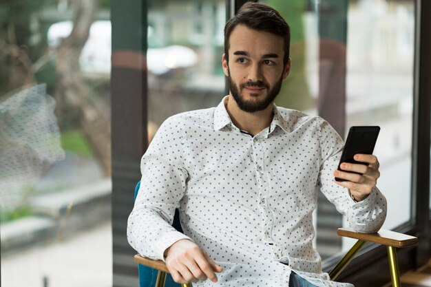 Foto gratuita alto ángulo joven macho sosteniendo móvil