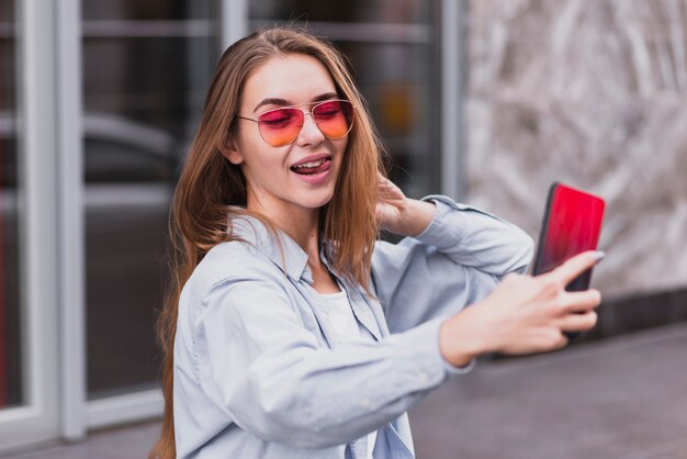 Alto ángulo juguetón hembra tomando selfies