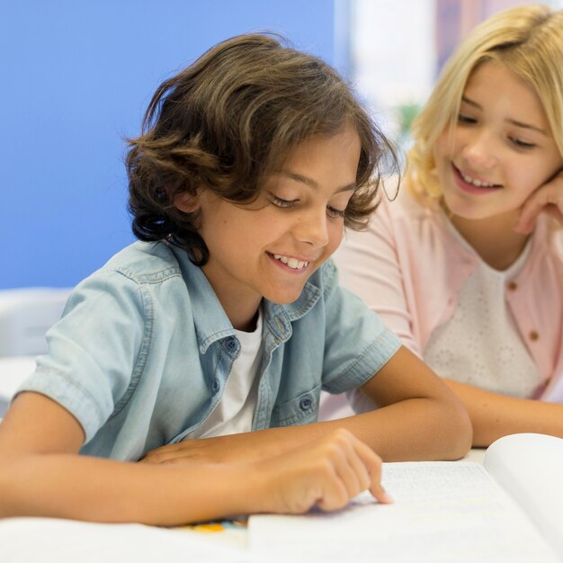 Alto ángulo de lectura de niña y niño