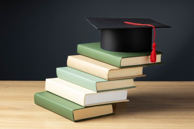 Alto ángulo de libros y un gorro de graduación para el día de la educación.