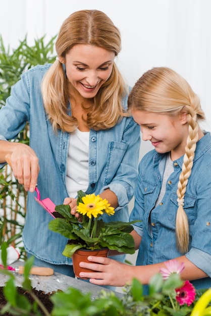 Alto ángulo madre e hija plantando flores