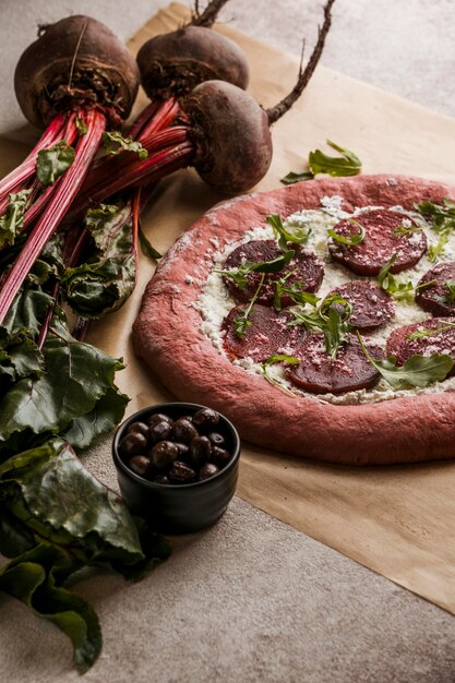 Alto ángulo de masa de pizza con queso y rodajas de remolacha