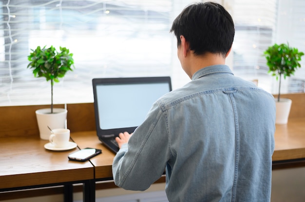 Alto ángulo masculino trabajando en la computadora portátil