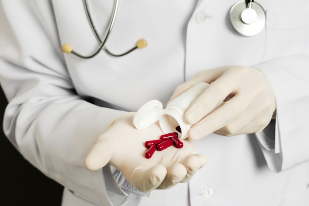 Alto ángulo de médico con guantes quirúrgicos con pastillas