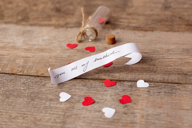 Alto ángulo de mensaje para el día de San Valentín con tubo y corazones.