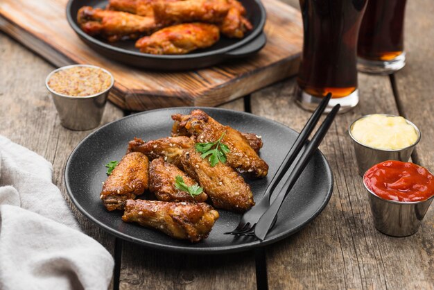 Alto ángulo de mesa con pollo frito en platos y bebidas gaseosas