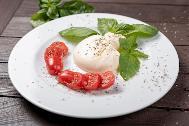 Alto ángulo de mozzarella y tomates cherry en mesa de madera