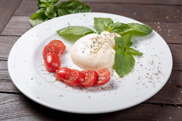 Alto ángulo de mozzarella y tomates cherry en mesa de madera