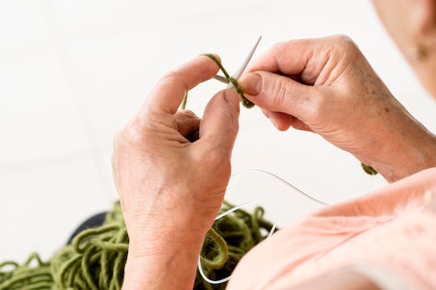 Alto ángulo de mujer con aguja de crochet