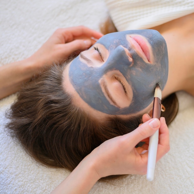 Foto gratuita alto ángulo de mujer recibiendo una mascarilla