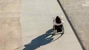 Foto gratuita alto ángulo de mujer en silla de ruedas en la calle