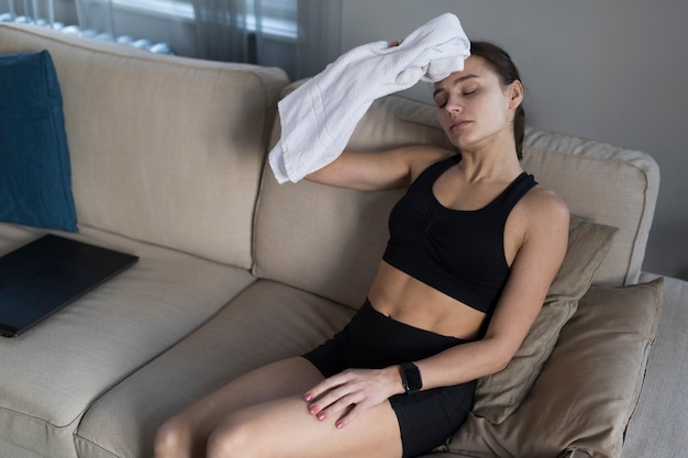 Foto gratuita alto ángulo de mujer en el sofá con su toalla