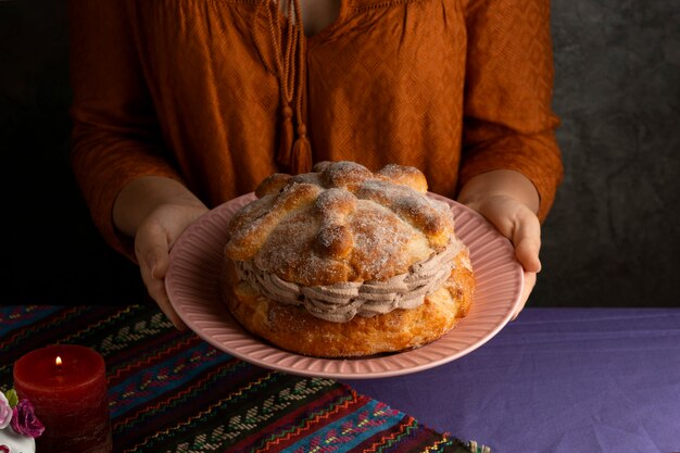 Alto ángulo de mujer sosteniendo pan de muerte