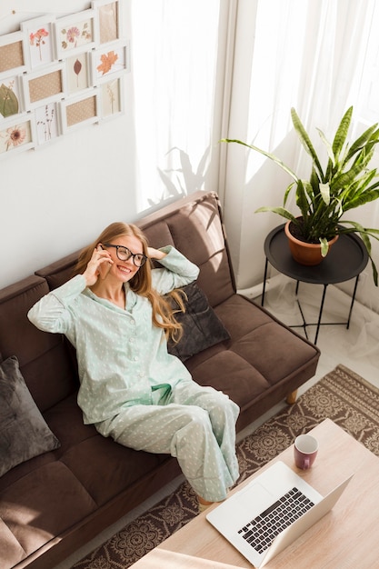 Alto ángulo de mujer trabajando en casa en pijama