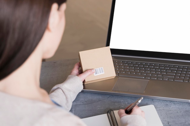 Alto ángulo de mujer trabajando en la computadora portátil y caja de retención