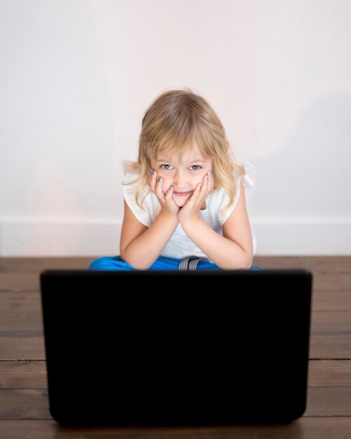 Alto ángulo de niña mirando en la computadora portátil