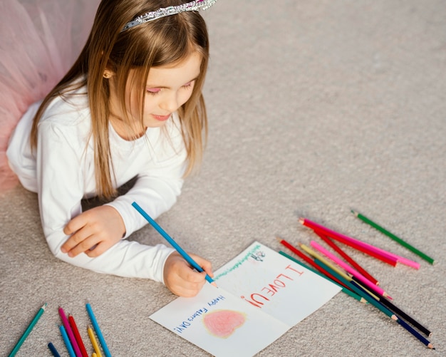 Alto ángulo de niña sosteniendo la tarjeta de dibujo para el día del padre