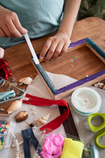 Foto gratuita alto ángulo de niño decorando marco de madera.