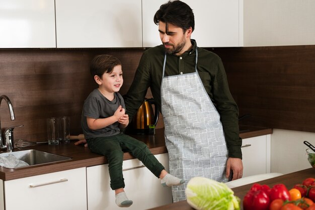 Alto ángulo niño y padre en la cocina