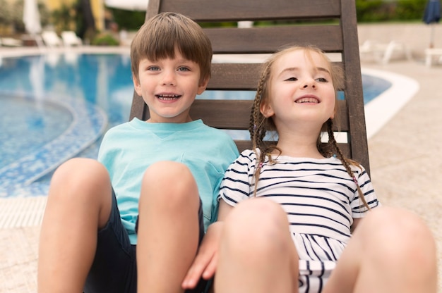 Foto gratuita alto ángulo para niños sentados en la cama sol