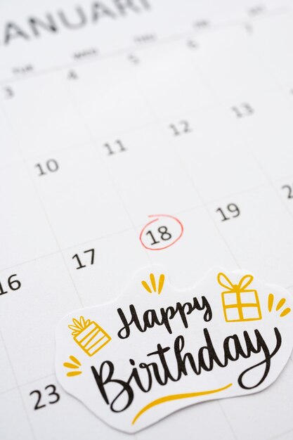 Alto ángulo de nota de cumpleaños agregada en calendario vibrante