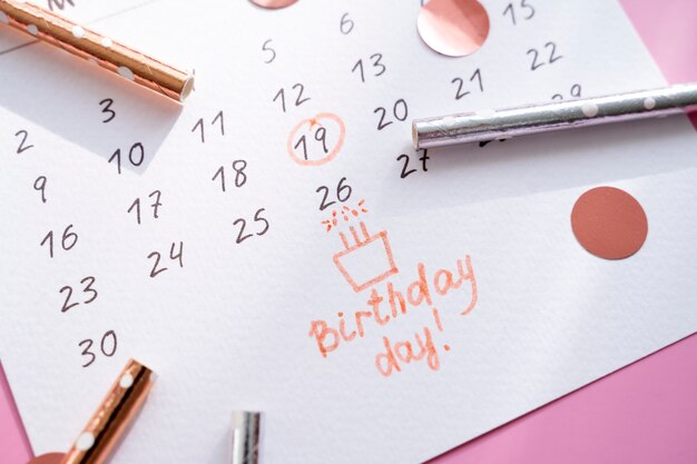 Alto ángulo de nota de cumpleaños agregada en calendario vibrante