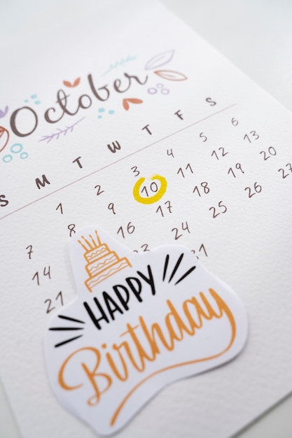 Alto ángulo de nota de cumpleaños agregada en calendario vibrante